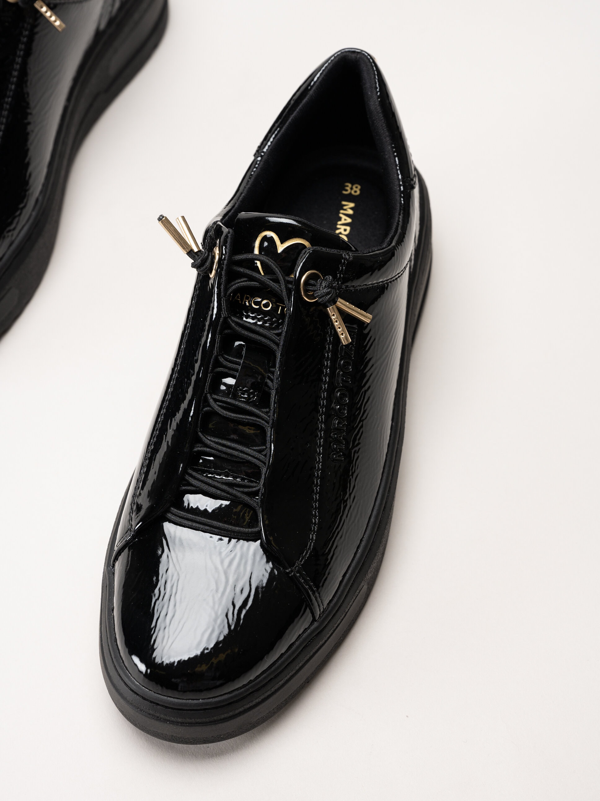 Marco Tozzi - Svarta sneakers i syntetlack med gulddetaljer