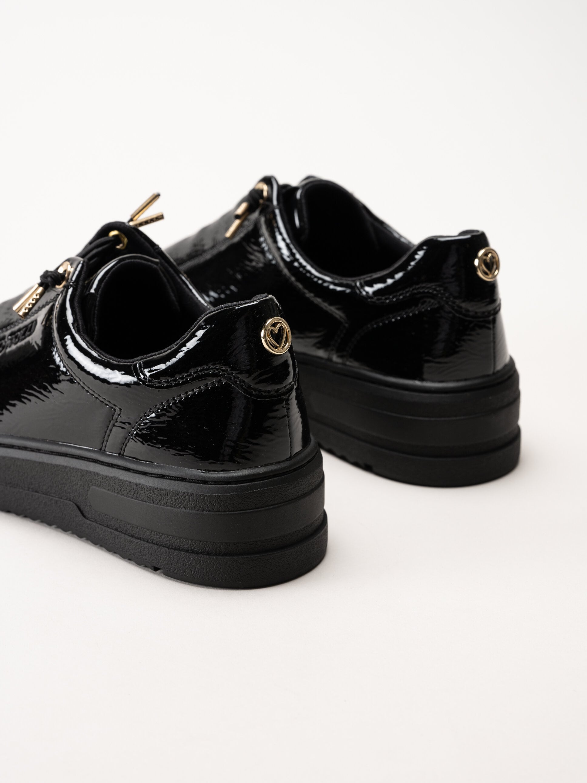 Marco Tozzi - Svarta sneakers i syntetlack med gulddetaljer